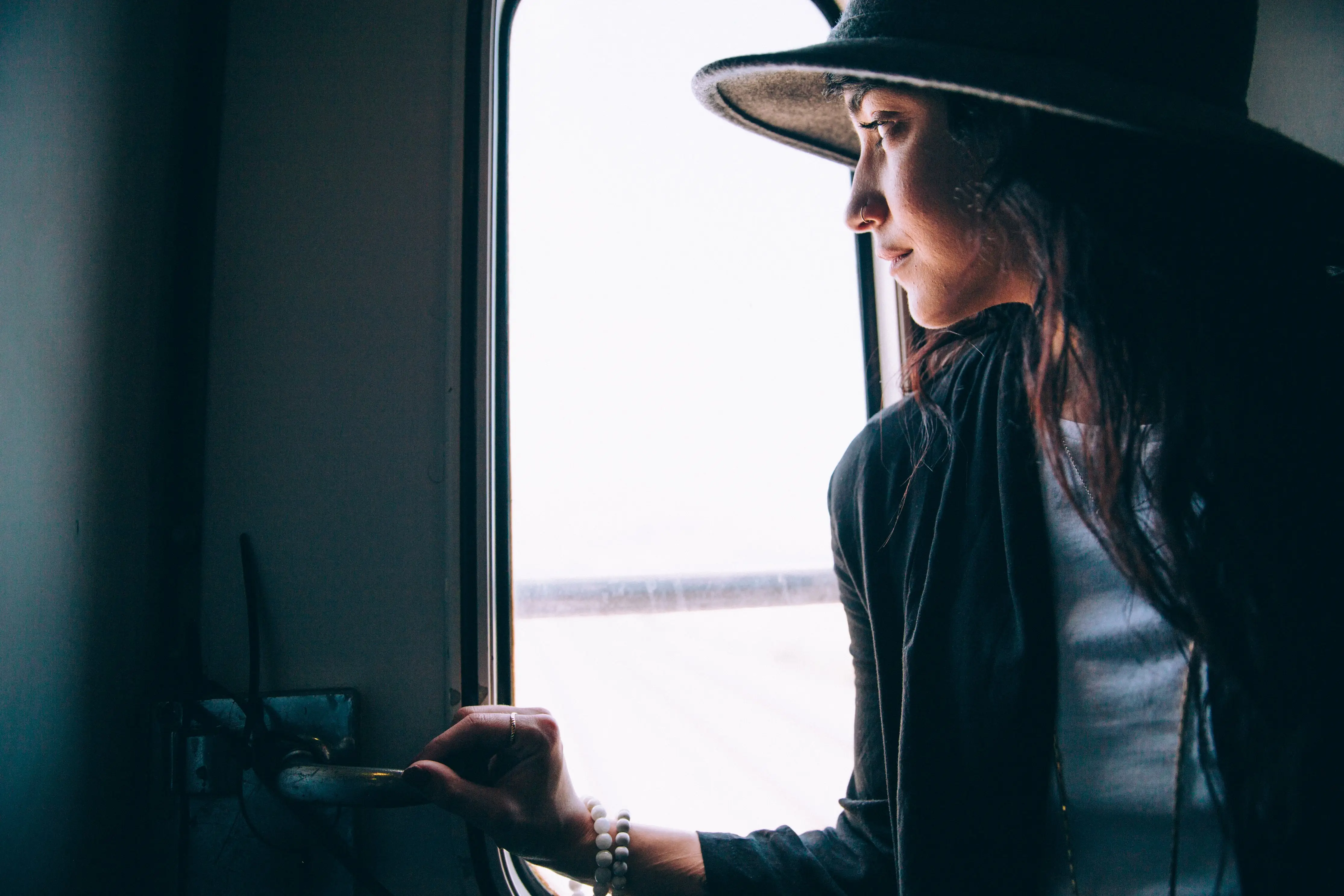 woman staring through an airplane window questioning her next steps