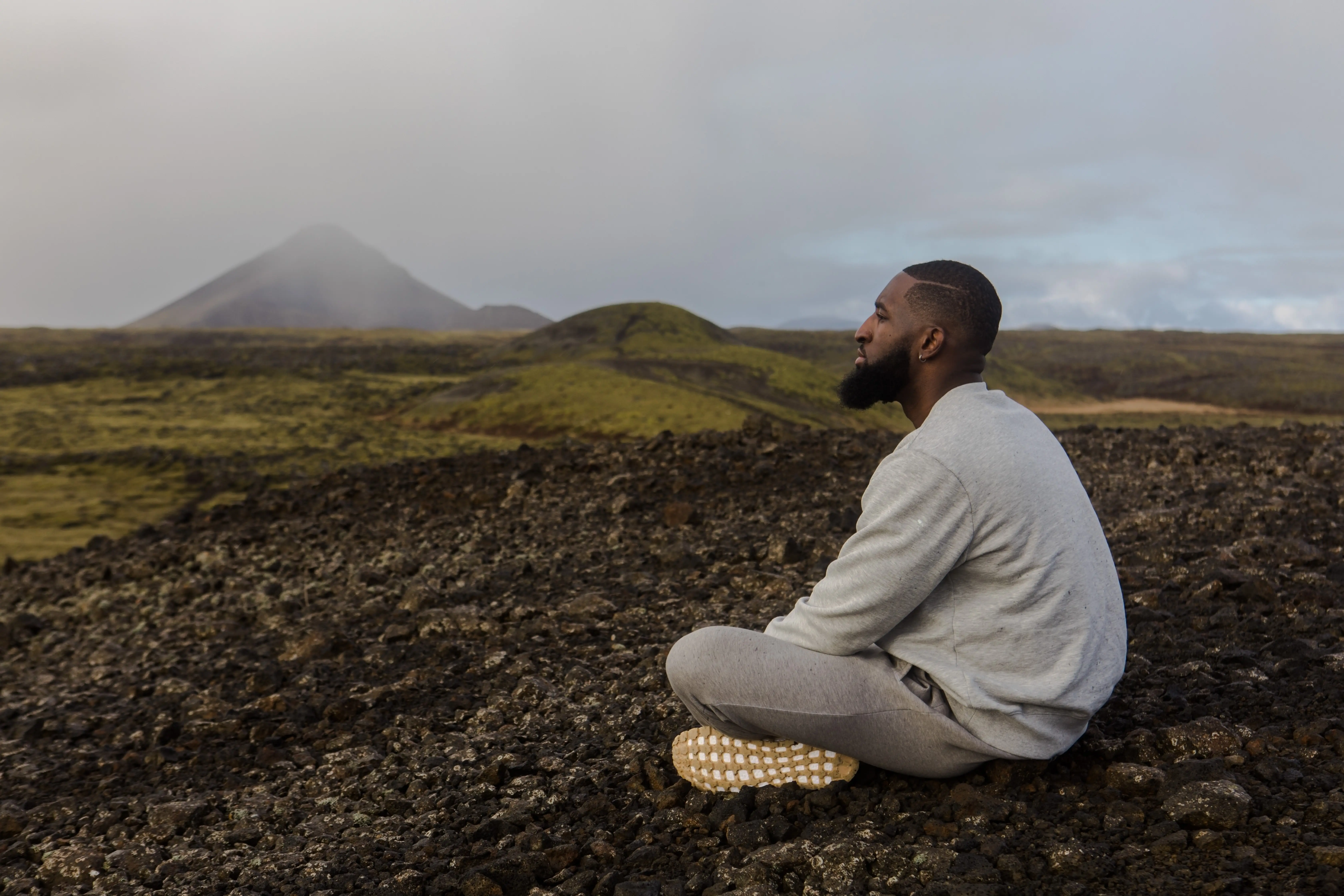 man meditating in a field and thinking about his goals